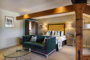 a bedroom with a bed and a green couch at The Castle Hotel, Conwy, North Wales - The Coaching Inn Group in Conwy