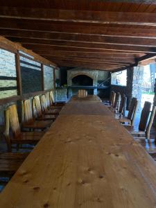 a long wooden table in a room with chairs at Holiday Houses Green Queen in Bihać +78 photos