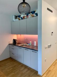 una cocina con armarios blancos y fregadero en Lux Optim Bled, en Bled