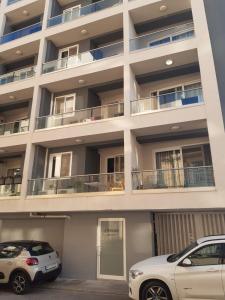 two cars parked in front of a building at Bright and beautifully furnished apartment close to seafront BFRA1-2 in Il-Gżira