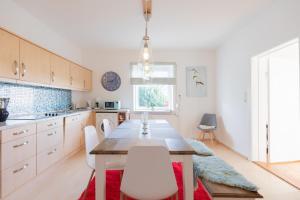 uma cozinha com uma mesa de madeira e cadeiras brancas em Grenzhaus am See em Rosenkranz