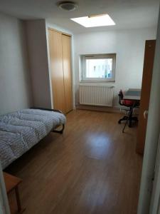 Zimmer mit einem Bett und einem Schreibtisch. in der Unterkunft Superbe appartement avec parking gratuit sur place in Nancy