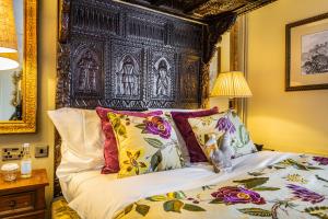 a bedroom with a bed with a large wooden headboard at The Castle Hotel, Conwy, North Wales - The Coaching Inn Group in Conwy
