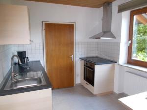 cocina con fregadero y puerta de madera en Ferienwohnung Familie Bauer, en Kelheim