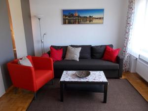 a living room with a couch and a red chair at Ferienwohnung Familie Bauer in Kelheim