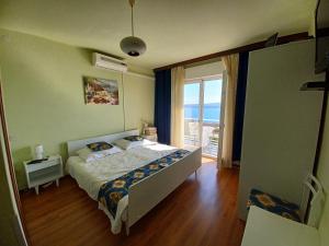 a bedroom with a bed and a view of the ocean at Guest House Djurdjica in Dramalj