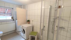 een badkamer met een douche en een wasmachine bij Gasthof Adler Ferienwohnung in Ichenhausen