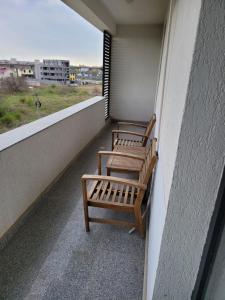 two benches sitting on a balcony with a view at Alina apartament 2 in Năvodari +4 photos
