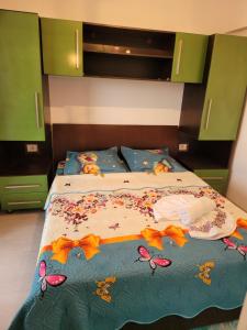 a bed with a blue comforter with butterflies on it at Alina apartament 2 in Năvodari