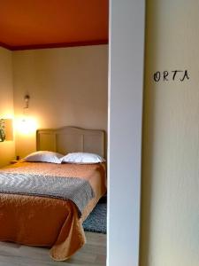 B&B Tra i Laghi في Casale Corte Cerro: غرفة نوم بسرير بسقف برتقالي