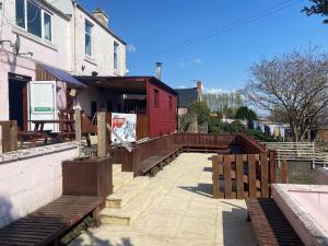 a patio with benches and a red building at Queensberry arms hotel in Kirkconnel