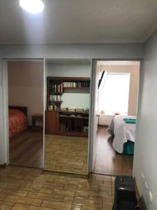 - une chambre avec un lit et un miroir dans l'établissement Hermoso Depto Vista al Valle, à Rancagua