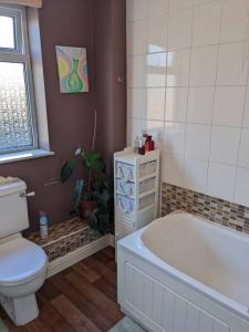 ein Badezimmer mit Badewanne, Toilette und Waschbecken in der Unterkunft Famous White Horse on the hill in Westbury