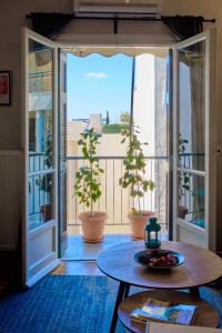 um quarto com uma mesa e uma varanda com plantas em K1 Apartment em Atenas