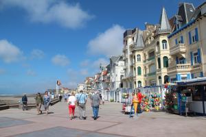 a group of people walking down a street with buildings at Du gite dans les Toiles in Wimereux