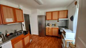 a kitchen with wooden cabinets and a stainless steel refrigerator at Tromso Coco Apartments in Center in Tromsø