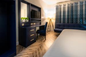 a hotel room with a bed and a desk and a couch at Da Vinci's Hotel in Derry Londonderry