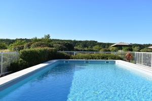 a swimming pool with blue water in a yard at Relais des Vigiers in Monestier