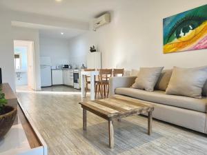 a living room with a couch and a table at Espectacular departamento sobre la laguna para parejas in Chascomús