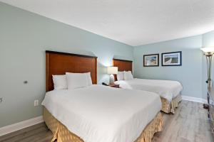 2 Betten in einem Zimmer mit blauen Wänden in der Unterkunft Sandy Beach Resort in Myrtle Beach