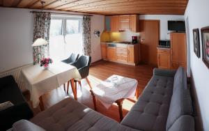 un soggiorno con divano e tavolo di Appartements Ferienwohnungen Alpenblick a Faistenau