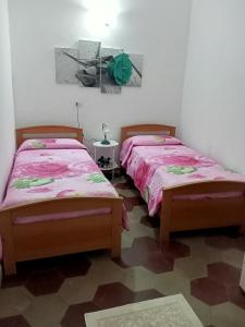2 Betten nebeneinander in einem Zimmer in der Unterkunft Appartamento vacanze Le rose in Bosa