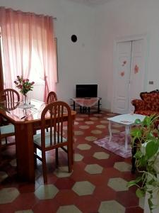ein Wohnzimmer mit einem Tisch und Stühlen in der Unterkunft Appartamento vacanze Le rose in Bosa