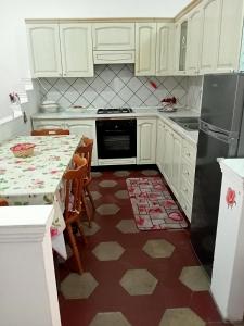 a kitchen with white cabinets and a black refrigerator at Appartamento vacanze Le rose in Bosa