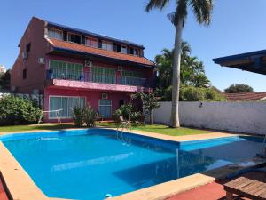 a house with a swimming pool in front of a building at Guembe al Rio Hostel in Puerto Iguazú