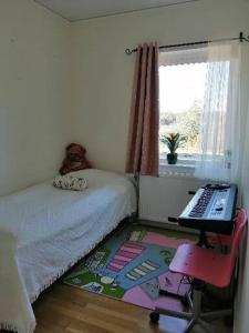 a bedroom with a bed and a desk with a computer at Havsnära Nybyggd Modern villa uthyres året runt! in Mönsterås
