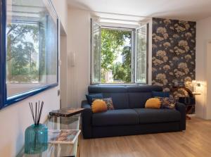 salon z niebieską kanapą i oknem w obiekcie Madeleine apartments - Arco della Pace w Mediolanie