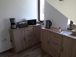 una cocina con armarios de madera y microondas en una encimera en Vila Ovidiu en Băile Herculane