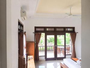 um quarto com uma porta que abre para um pátio em Putra Bisma Guesthouse em Ubud
