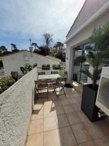 a patio with a table and chairs on a balcony at Havre de paix 4 étoiles, 2 pièces calme et lumineux à 100 mètres de la plage in Saint-Georges-de-Didonne