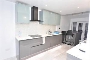 a kitchen with blue cabinets and a counter top at Luxury 5 Bedroom House with Free Parking on Site in Hornchurch