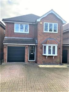 a brick house with a garage on a brick driveway at Luxury 5 Bedroom House with Free Parking on Site in Hornchurch