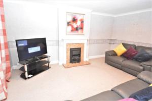 a living room with a couch and a fireplace at Luxury 5 Bedroom House with Free Parking on Site in Hornchurch