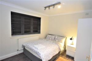 a bedroom with a bed and a window at Luxury 5 Bedroom House with Free Parking on Site in Hornchurch