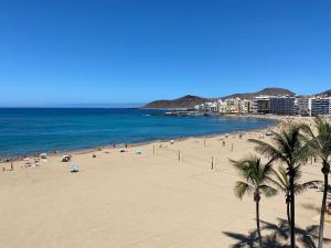 una spiaggia con molta gente e l'oceano di Las Canteras beach and sea, wifi, terraza, comodidad a Las Palmas de Gran Canaria