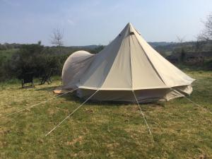 a tent in the grass in a field at EcoCamping d Hacadour in Mellionnec