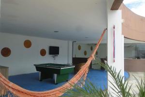 a hammock in a room with a pool table at Por do Sol Pousada Praia in São Luís