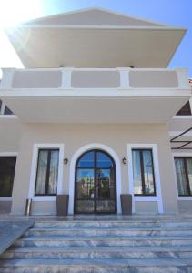 a large white building with a large glass door at Ermis Hotels & Resorts in Lygia