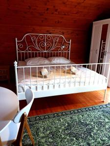 a white bed in a room with a wooden wall at Vila Gorenka in Bled