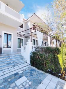 a white house with a staircase in front of it at Ermis Hotels & Resorts in Lygia