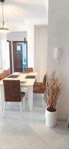 une salle à manger avec une table blanche et une plante en pot dans l'établissement Beautiful apartment near downtown N 40, à Tanger