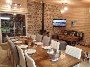 uma sala de jantar com uma mesa de madeira e cadeiras em Lama-Gîte-des-Puys chalet écologique à 30km des pistes, visite aux lamas Charge VE em Montaigut-le-Blanc