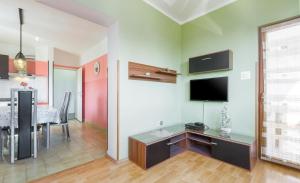a living room with a table and a tv on a wall at Spacious new app for 5 persons, close beach&city in Poreč