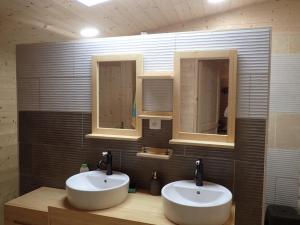 a bathroom with two sinks and two mirrors at Lama-Gîte-des-Puys chalet écologique à 30km des pistes, visite aux lamas Charge VE in Montaigut-le-Blanc