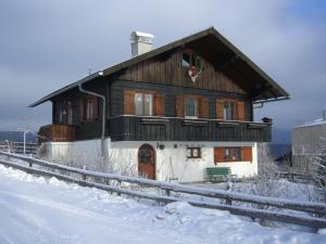 ein großes Holzhaus im Schnee davor in der Unterkunft CHALET MARESI in Schladming