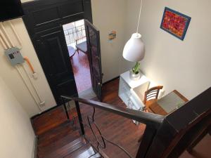 a stairway with a black door and a table and chair at Casa Elizabeth in Quetzaltenango